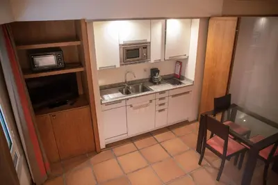 a small kitchen with a sink and a microwave at Apartamentos Turisticos Atlantida in Funchal