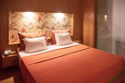 a bedroom with a large bed with orange sheets at Apartamentos Turisticos Atlantida in Funchal