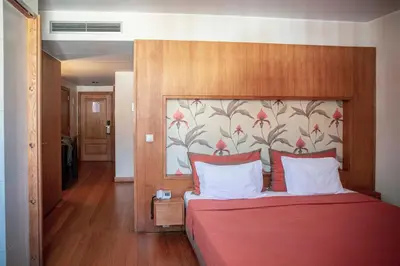 a bedroom with a red bed with a floral wall at Apartamentos Turisticos Atlantida in Funchal