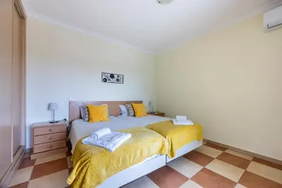 a bedroom with a bed with yellow sheets and yellow pillows at Montinhos Nature Stay in Luz