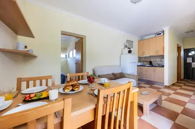 a dining room and kitchen with a table and chairs at Montinhos Nature Stay in Luz