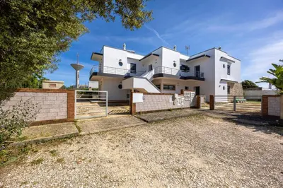 a white house with a fence in front of it at Montinhos Nature Stay in Luz