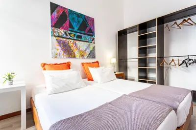 a bedroom with a large white bed with orange pillows at Casa da Ribeira in Funchal