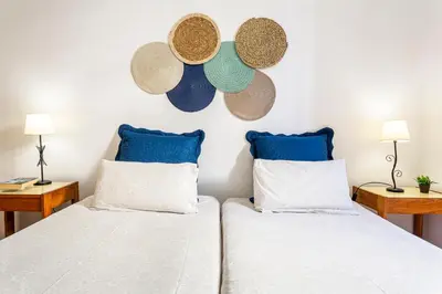 two beds in a room with hats on the wall at Casa da Ribeira in Funchal