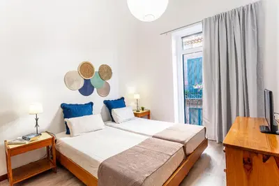 a bedroom with a large bed and a window at Casa da Ribeira in Funchal