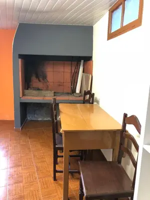 a dining room with a table and a fireplace at Casa da Igreja in Santana