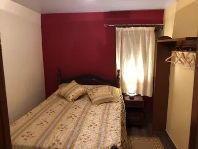 a bed in a red room with a window at Casa da Igreja in Santana