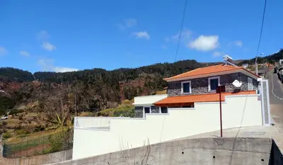 a house on top of a wall with a road at Quinta Escola in Arco da Calheta