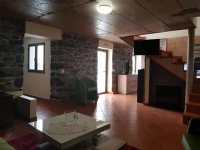 a living room with a table and a fireplace at Quinta Escola in Arco da Calheta