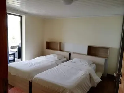 two beds in a hotel room with white sheets at Quinta Escola in Arco da Calheta