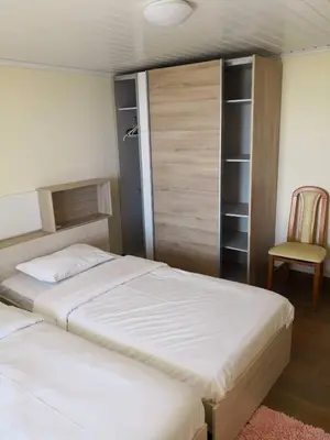 a bedroom with two beds and a chair at Quinta Escola in Arco da Calheta