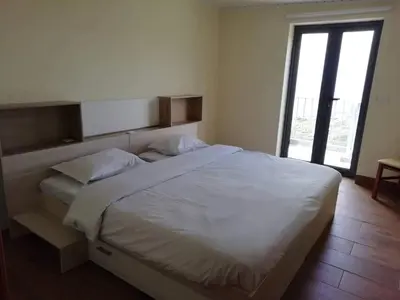 a bedroom with a large white bed and a window at Quinta Escola in Arco da Calheta