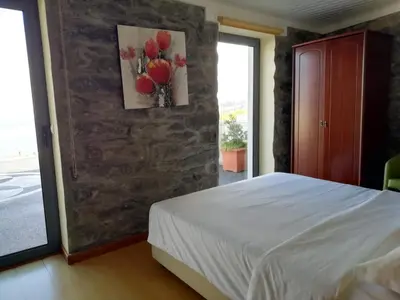 a bedroom with a bed and a painting on the wall at Quinta Escola in Arco da Calheta