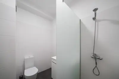 a white bathroom with a shower and a toilet at Golden Star AV by An Island Apart in Funchal
