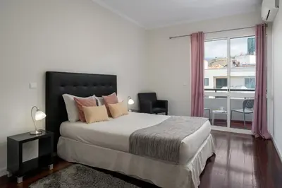 a bedroom with a large bed and a large window at Golden Star AV by An Island Apart in Funchal