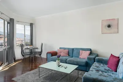 a living room with a blue couch and a table at Golden Star AV by An Island Apart in Funchal