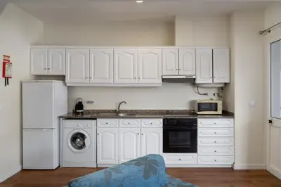 a kitchen with white cabinets and a sink and a dishwasher at Golden Star AV by An Island Apart in Funchal