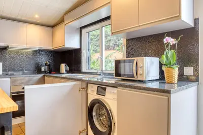 a kitchen with white cabinets and a microwave at Casa da Praia, a Home in Madeira in Tábua