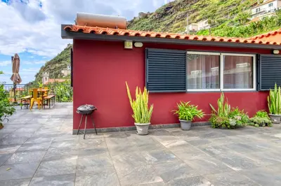 a red building with plants in front of it at Casa da Praia, a Home in Madeira in Tábua
