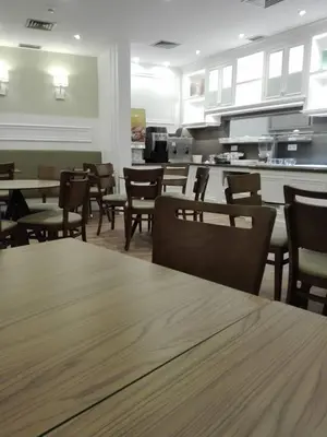 a dining room with tables and chairs and a kitchen at Hotel Do Centro in Funchal
