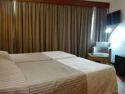 a hotel room with a bed and a chair at Hotel Do Centro in Funchal