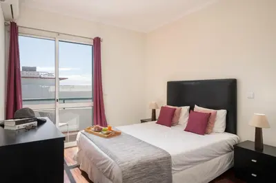 a bedroom with a large bed and a large window at Golden Star AU by An Island Apart in Funchal