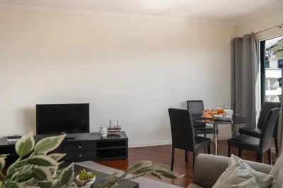 a living room with a tv and a table with chairs at Golden Star AU by An Island Apart in Funchal