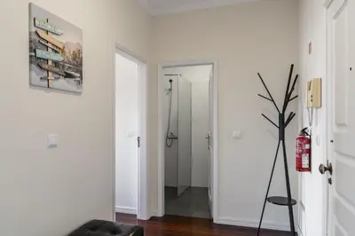 a white hallway with a black chair and a bathroom at Golden Star AU by An Island Apart in Funchal