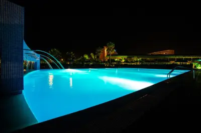 a large swimming pool lit up at night at Vila Baleira Porto Santo in Porto Santo