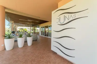 a lobby with plants in white pots in a building at Vila Baleira Porto Santo in Porto Santo