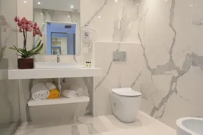 a bathroom with a toilet and a sink and a mirror at Ocean Gardens in Funchal