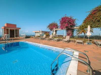 a swimming pool with chaise lounge chairs next to a resort at Ocean Gardens in Funchal