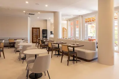 a restaurant with tables and chairs and a bar at Belavista Da Luz - Wellness & Lifestyle Hotel in Luz