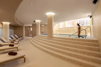 a swimming pool with stairs and a person in the background at Belavista Da Luz - Wellness & Lifestyle Hotel in Luz