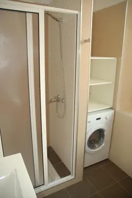 a bathroom with a shower and a washing machine at Flat view Mercado in Funchal