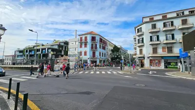 a group of people crossing a street in a city at Flat view Mercado in Funchal