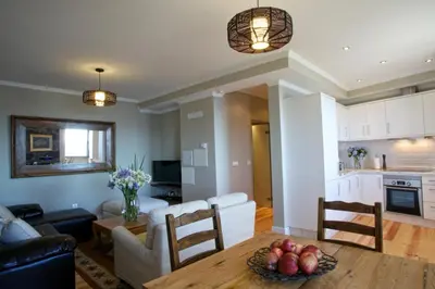 a kitchen and living room with a table and a couch at The Docks in Paul do Mar