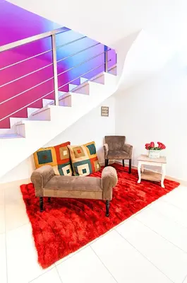 a living room with a couch and chairs on a red rug at Mareta Beach - Boutique Bed & Breakfast in Sagres