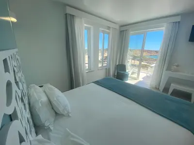 a bedroom with a bed with a view of the ocean at Mareta Beach - Boutique Bed & Breakfast in Sagres