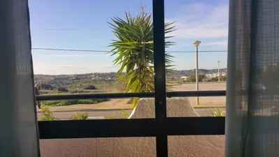 a view of a palm tree from a window at Sunset Relax Porch in Lagos