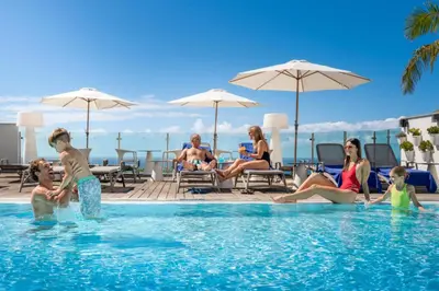 a group of people sitting in a swimming pool at Vila Baleira Funchal in Funchal