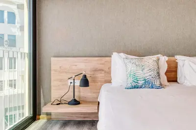 a bedroom with a bed with a lamp next to a window at Vila Baleira Funchal in Funchal