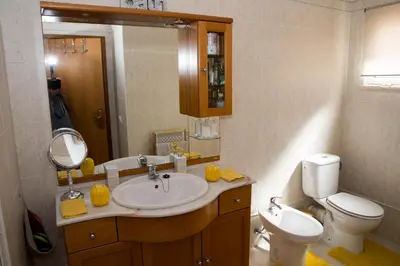 a bathroom with a sink and a toilet and a mirror at ZiZis Place in Santa Cruz