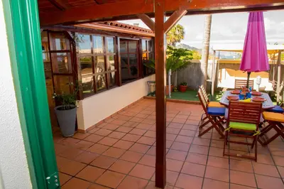 a screened in porch with a table and chairs at ZiZis Place in Santa Cruz