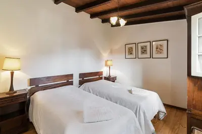 a bedroom with two white beds and a window at Quinta Florença - By WeHost in Funchal
