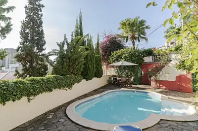 a swimming pool in a yard with trees and plants at Quinta Florença - By WeHost in Funchal