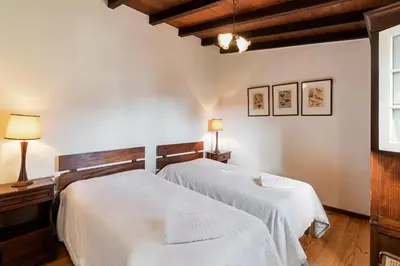a bedroom with two white beds and a window at Quinta Florença - By WeHost in Funchal