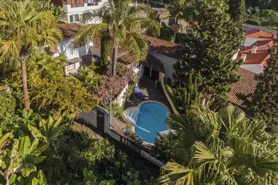 an overhead view of a building with a swimming pool and palm trees at Quinta Florença - By WeHost in Funchal
