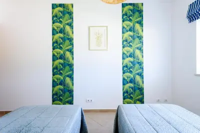 a bedroom with a bed with a blue comforter at Boavista in Quatro Estradas