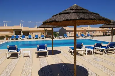 a pool with chairs and umbrellas and a swimming pool at Boavista in Quatro Estradas